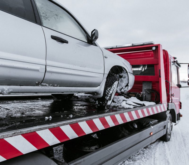 Car on tow truck on snow road